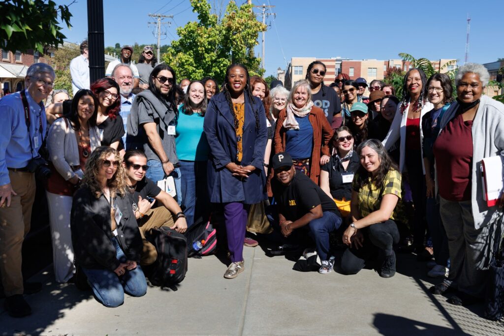 The group of 50 PaX fellows poses on a sidewalk