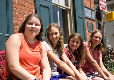 TEEN READING LOUNGE PARTICIPANTS SIT OUTSIDE PRIESTLEY FORSYTH MEMORIAL LIBRARY