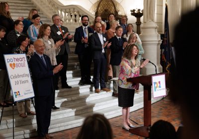 As members of the broader Heart & Soul family look on, PA Humanities executive director Laurie Zierer welcomes people to a special celebration of 10 years of PA Heart & Soul at the Capitol Rotunda in Harrisburg. Photo by Rustbelt Mayberry Photography.