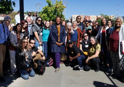 The group of 50 PaX fellows poses on a sidewalk