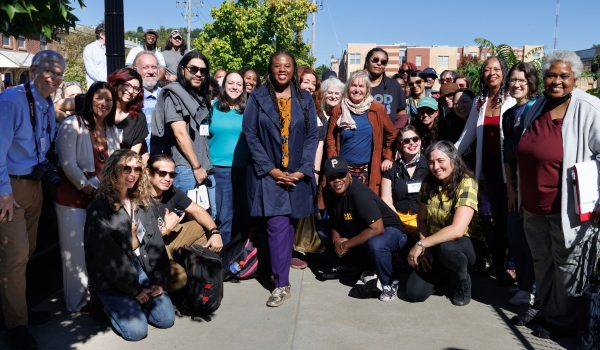 The group of 50 PaX fellows poses on a sidewalk