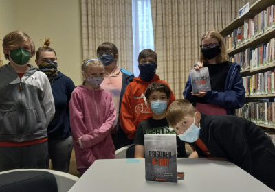 Members of the Brandywine Community Library Teen Reading Lounge location pose with their latest book club read, "Prisoner B-3087."