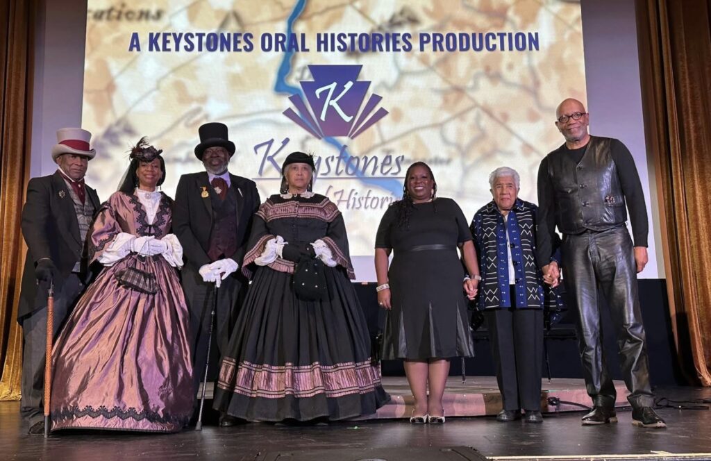 Keystone Oral Histories founder Bryan Wade, right, is joined on stage by four members of the Pennsylvania Past Players dressed in period costumes, local historian Ruth Lodge, second from right, and moderator Rogette Harris, third from right, following a screening and discussion of Wade’s documentary, “A History of the Underground Railroad and Abolitionists Throughout South Central Pennsylvania.”